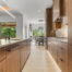 Full kitchen remodel with custom wood cabinets, natural stone waterfall island, and ambient lighting in Dripping Springs Texas