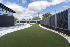 Outdoor living space with putting green and water feature added to custom home outdoor space in Austin Texas
